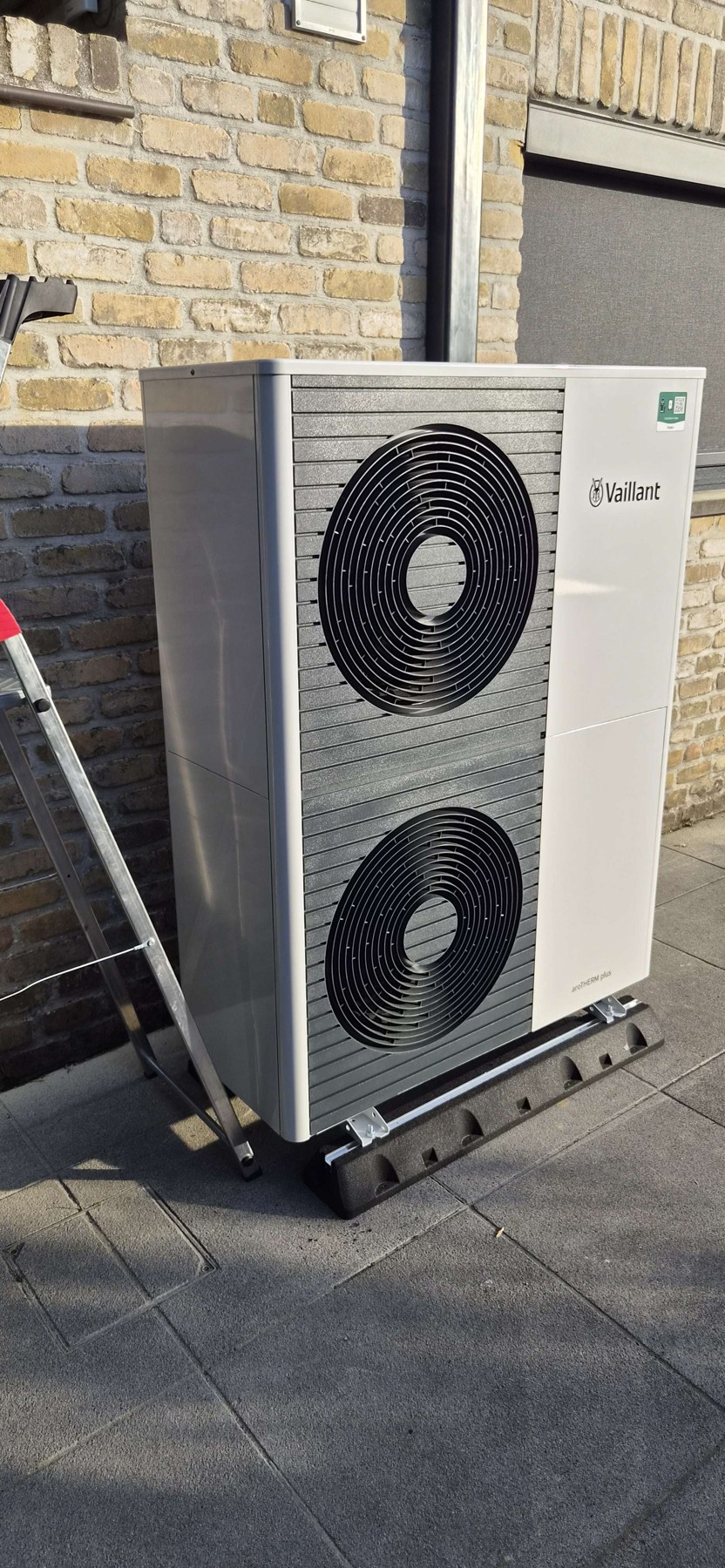 Vaillant-buitenunit naast de bakstenen gevel in Brugge